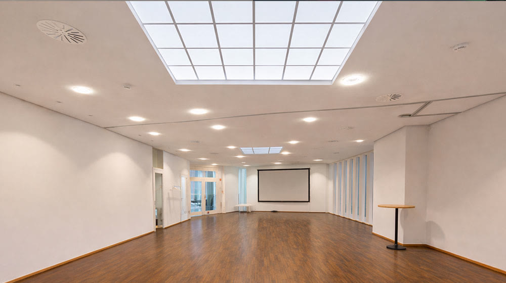 Leerer Saal mit Oberlicht und Leinwand in der Location L