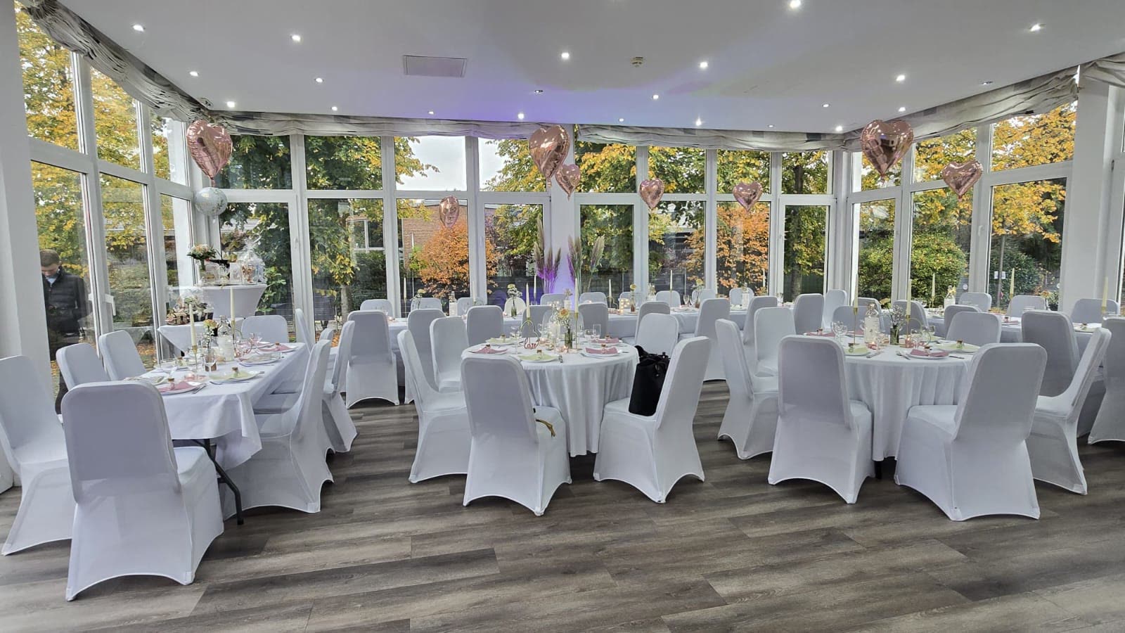 Festlich eingedeckter Saal mit runden Tischen in der Location M